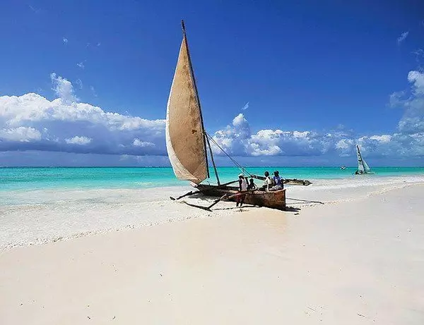 Fiskebåt på hvit sandstrand på Zanzibar